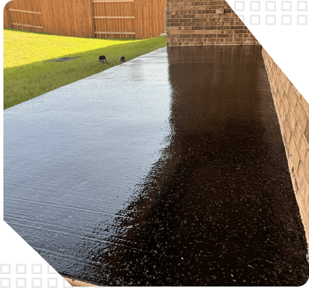 A picture of a driveway with black asphalt.