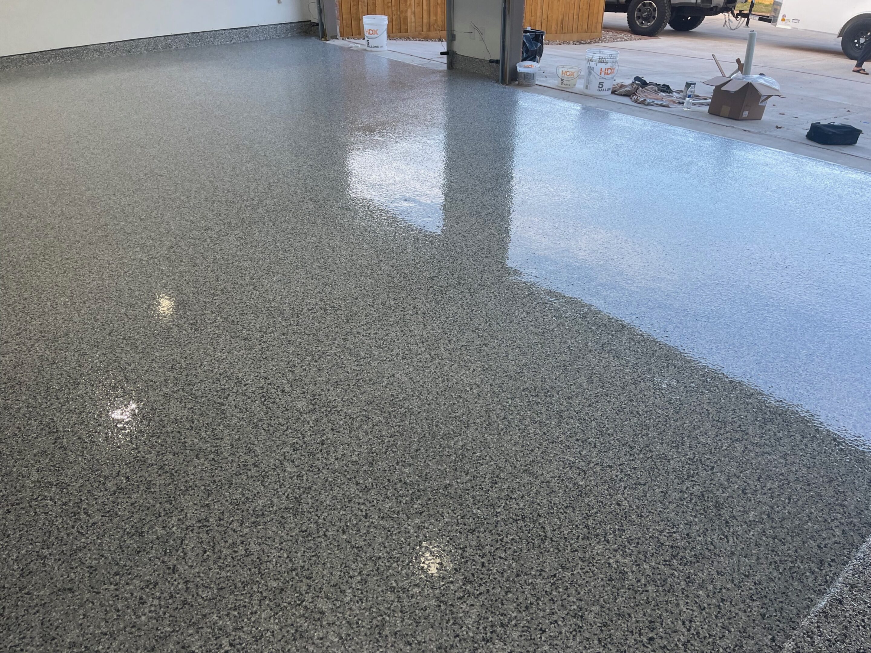A garage floor with a shiny surface and some white spots