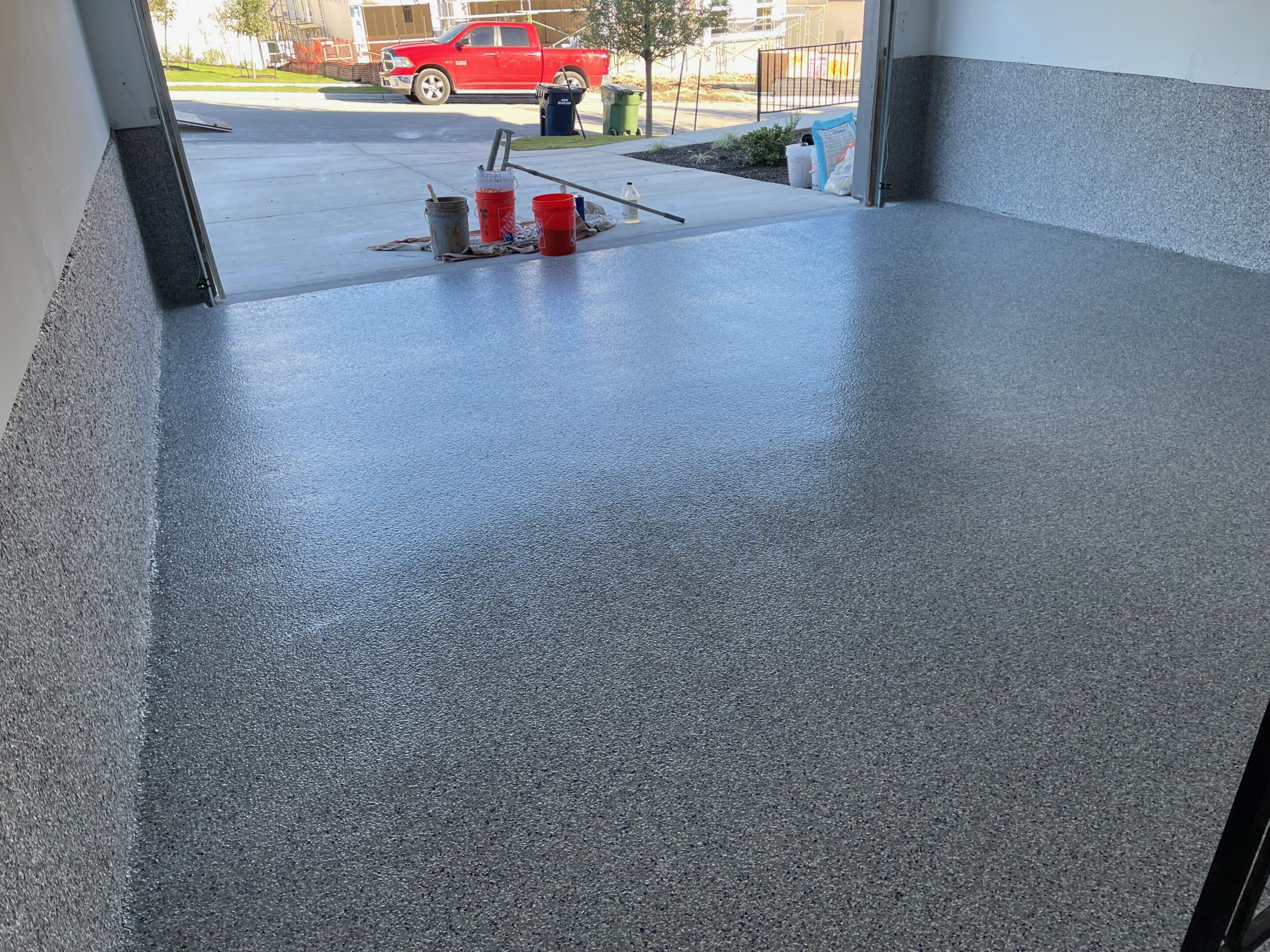 A couple of cans sitting on top of a concrete floor.