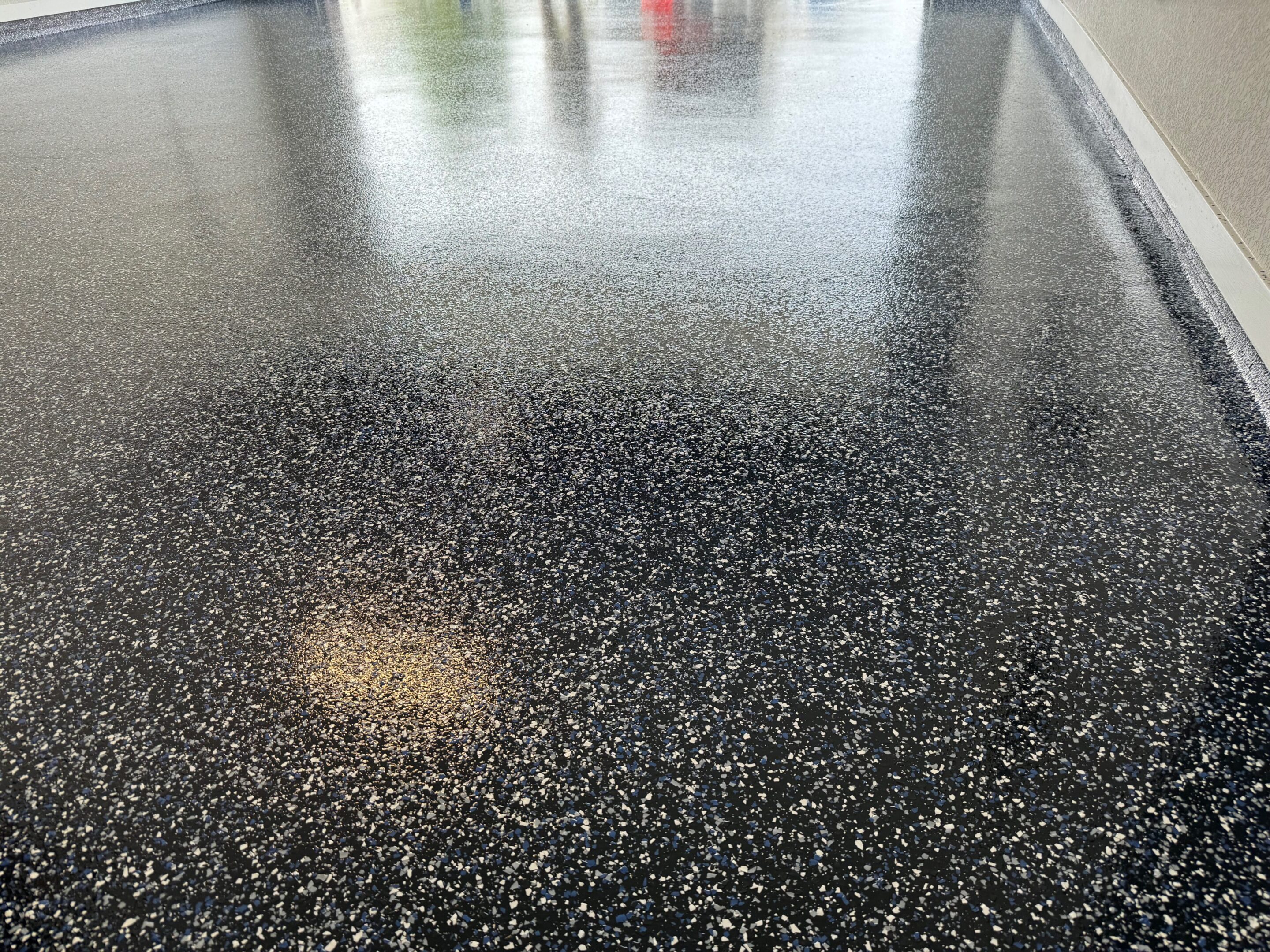 A black floor with some white spots on it