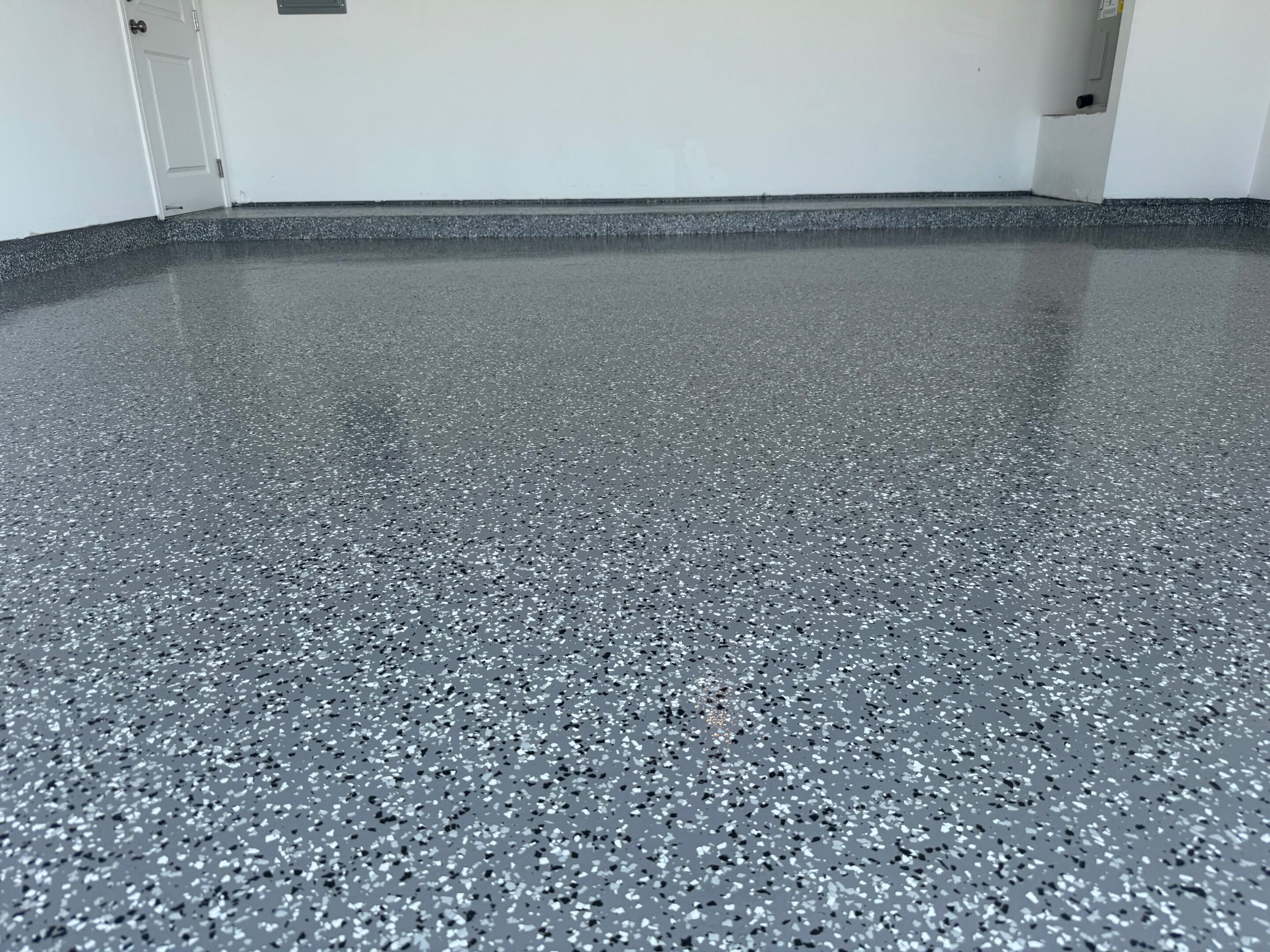A garage floor with a gray speckled finish.