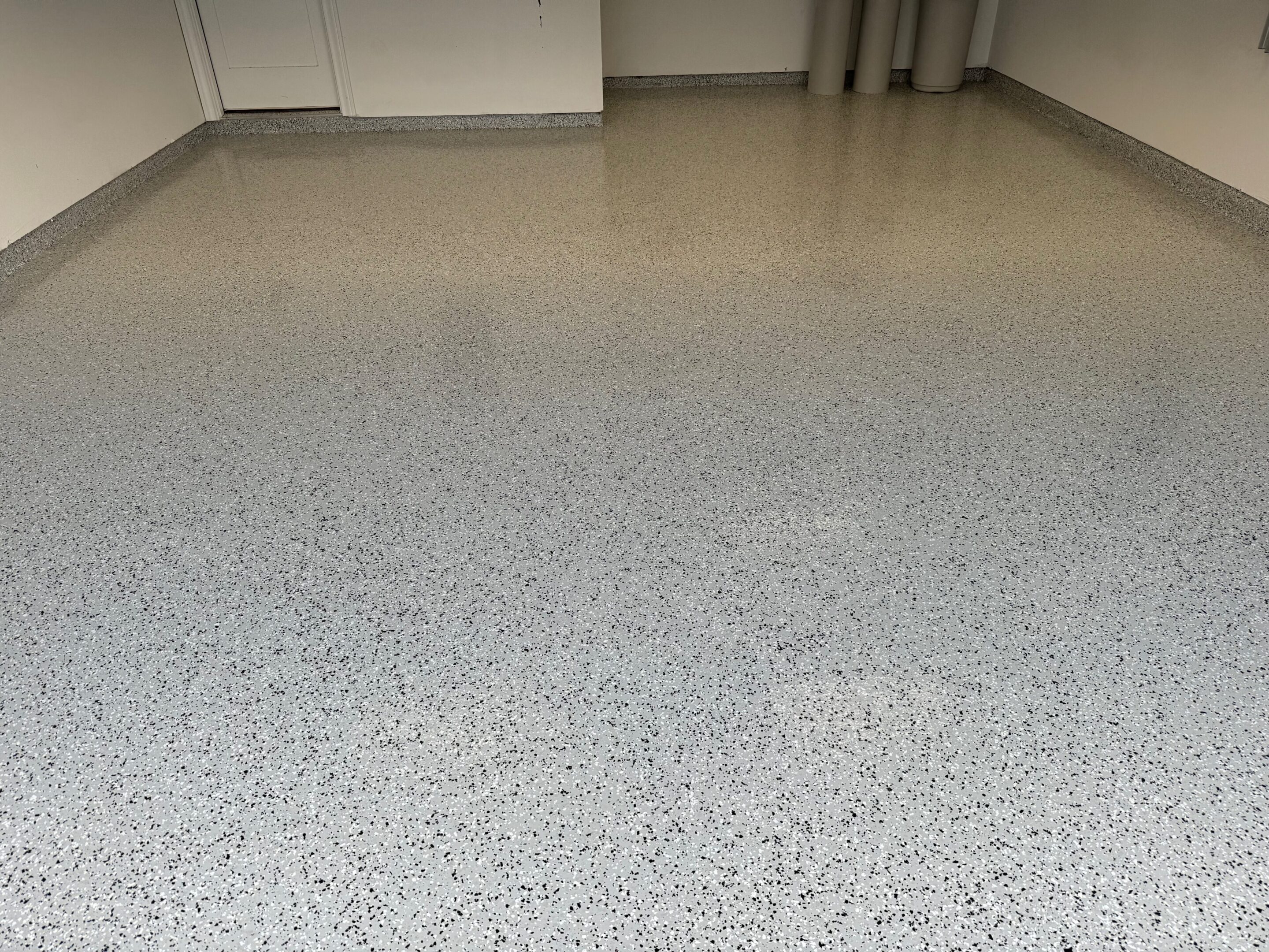 A white floor with some gray and black spots