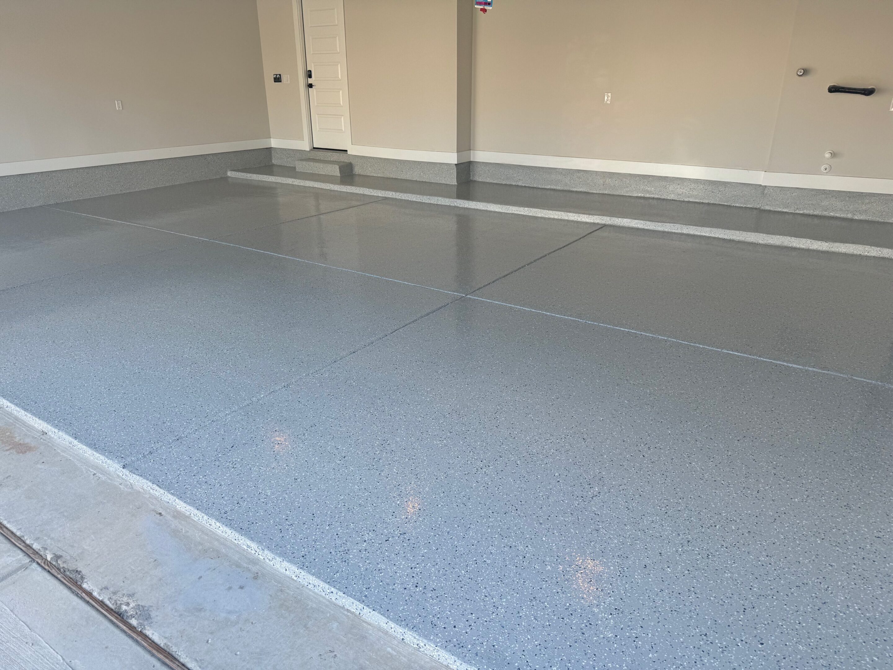 A garage floor that has been painted grey.