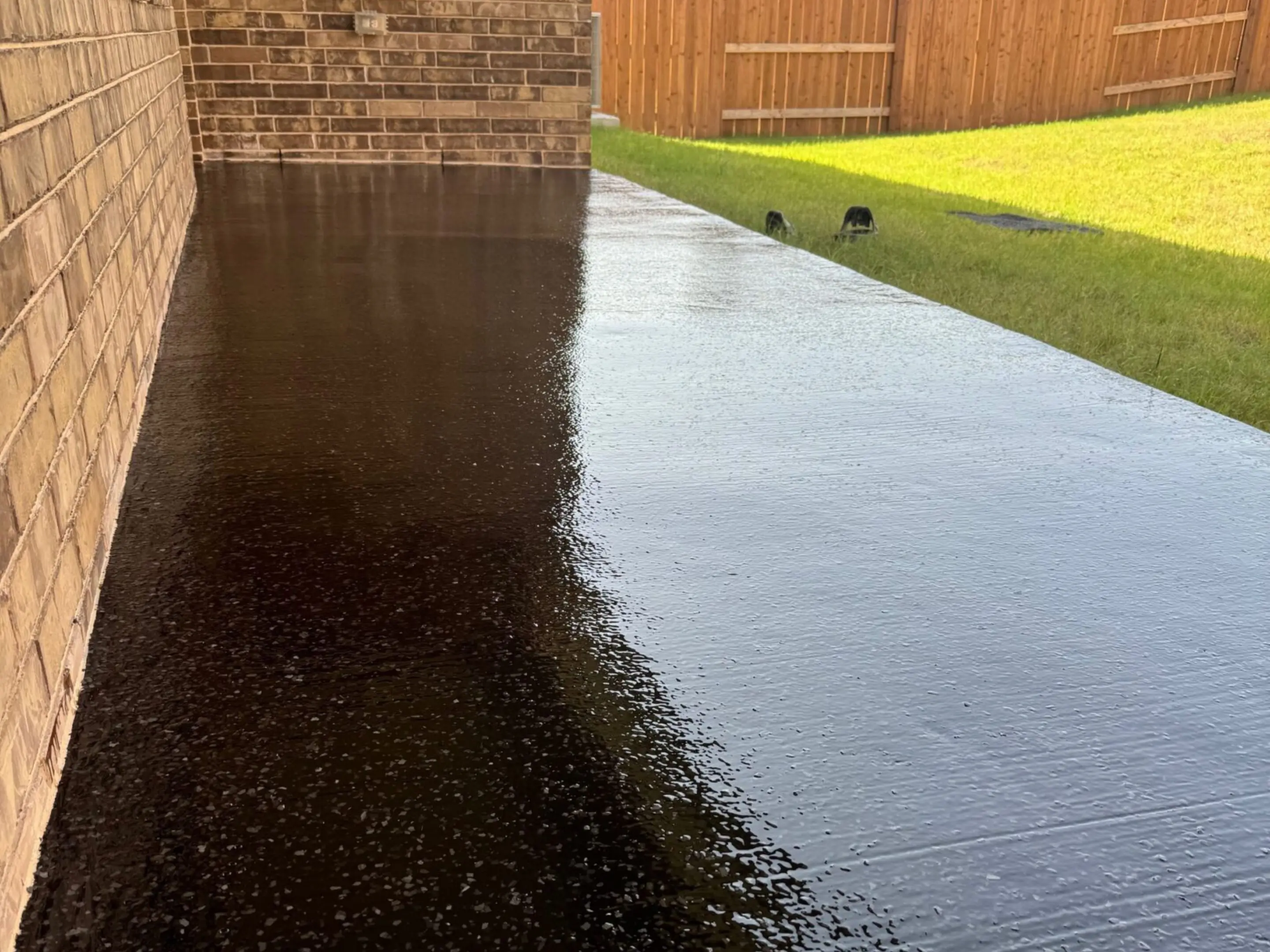 A black driveway with water running down it.